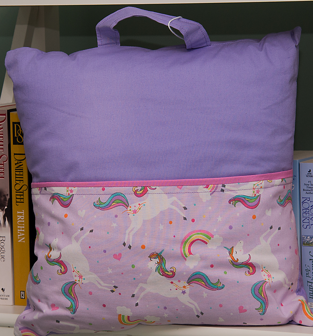 reading pillow for kids with a front pocket easy to grab when traveling to carry books, coloring books, crayons.